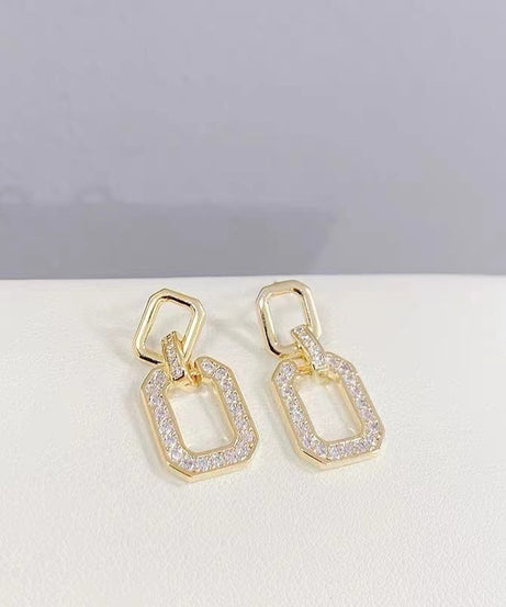 Close-up of geometric gold drop earrings, pavé detail