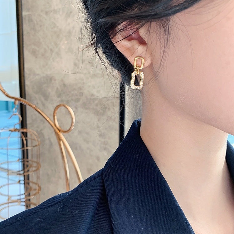 Side view: geometric gold drop earrings on model