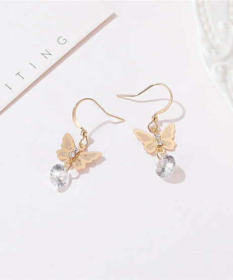 Butterfly crystal drop earrings in gold on white tray
