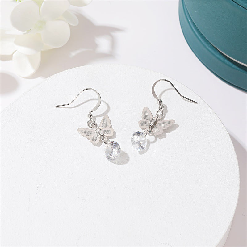 Butterfly crystal drop earrings in silver on white tray