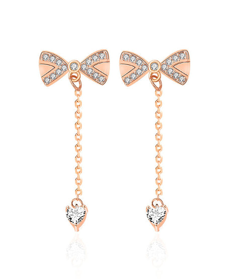 Close-up bow tassel studs with pavé heart