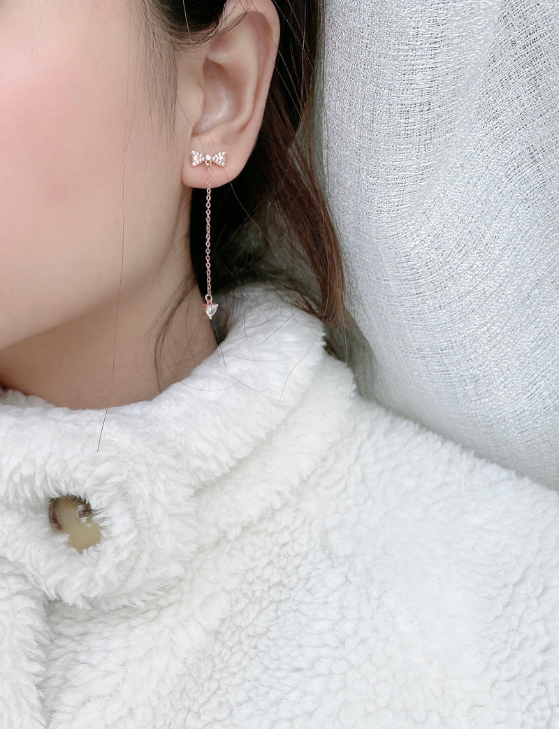 Model wearing rose-gold bow tassel drop stud earrings