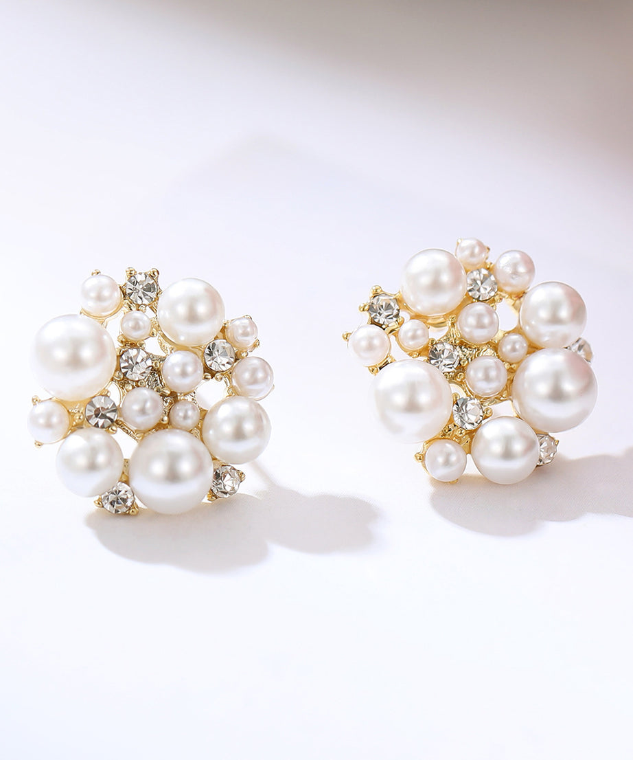 Pair of pearl earrings with gold accents on a white background