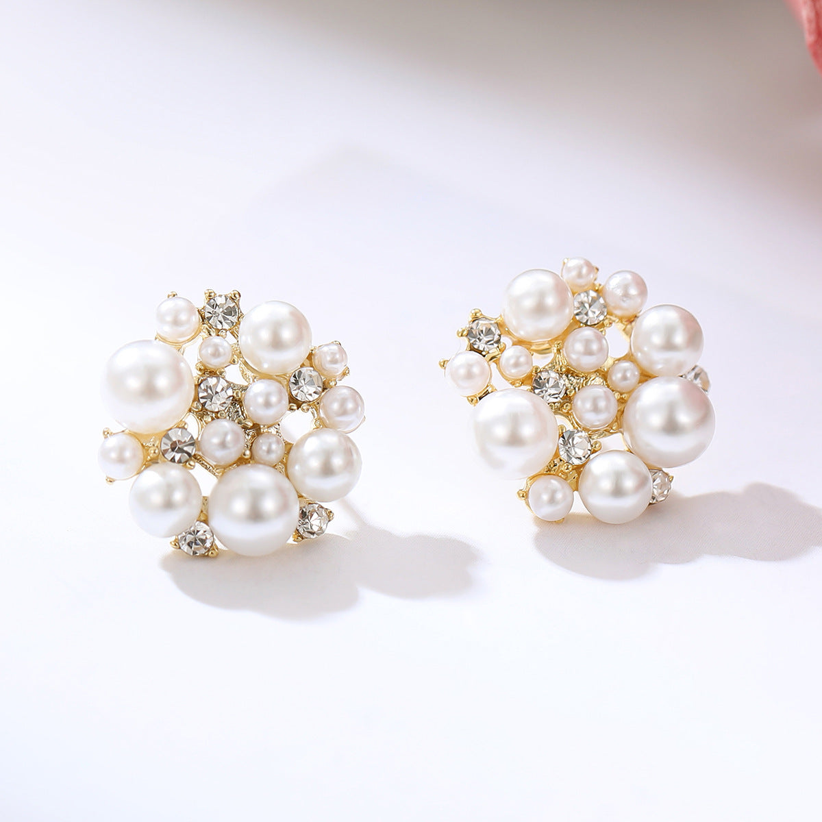 Pair of pearl earrings with gold accents on a white background
